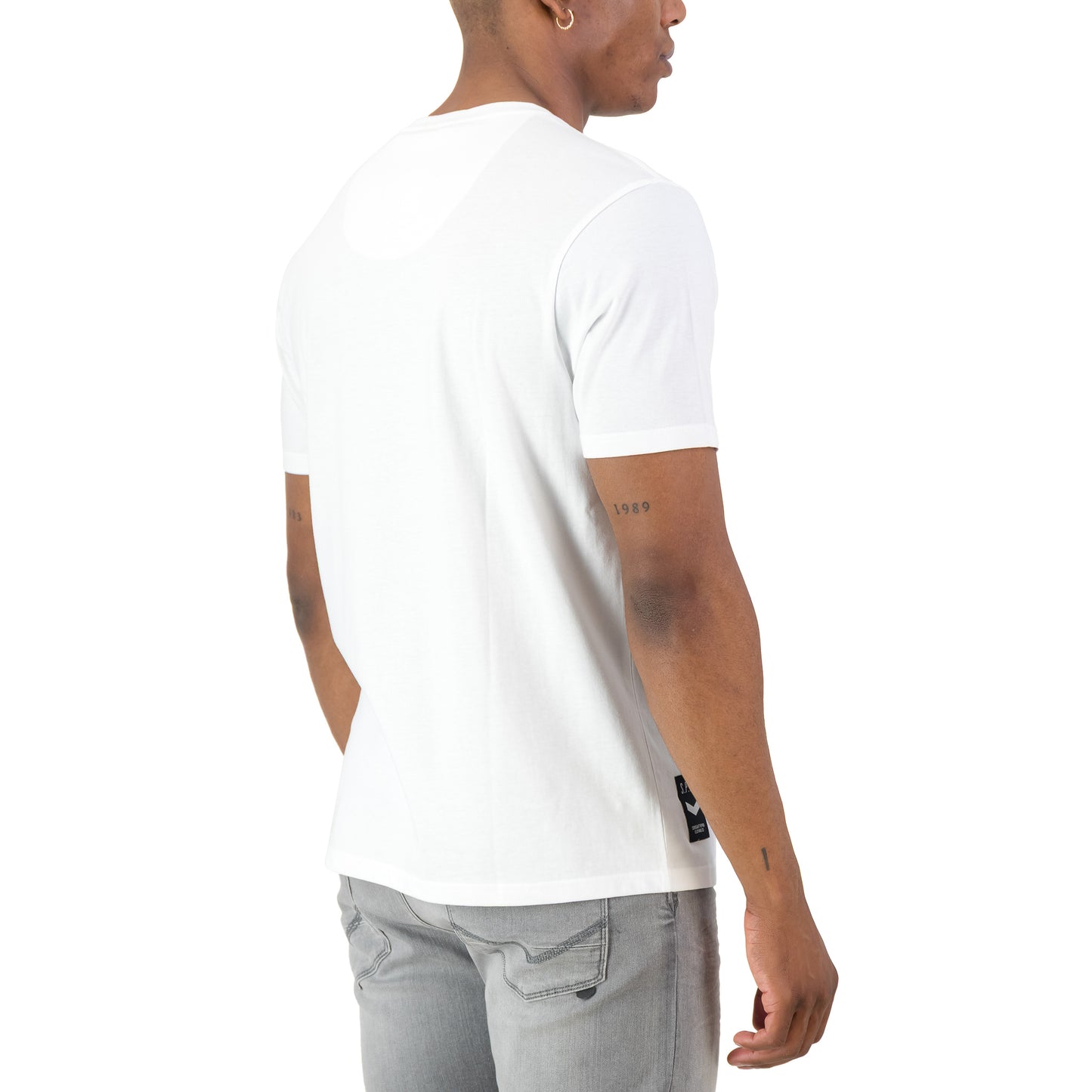 Back view of a man wearing the Surge Atlas Tee - White, showcasing its refined streetwear style and comfort.