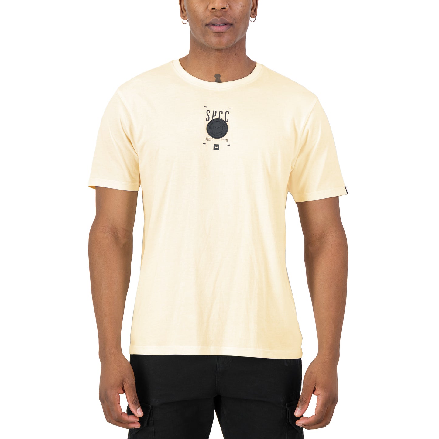 Romain Tee - Off White featuring SPCC print and badge on soft-touch fabric, styled for streetwear versatility.
