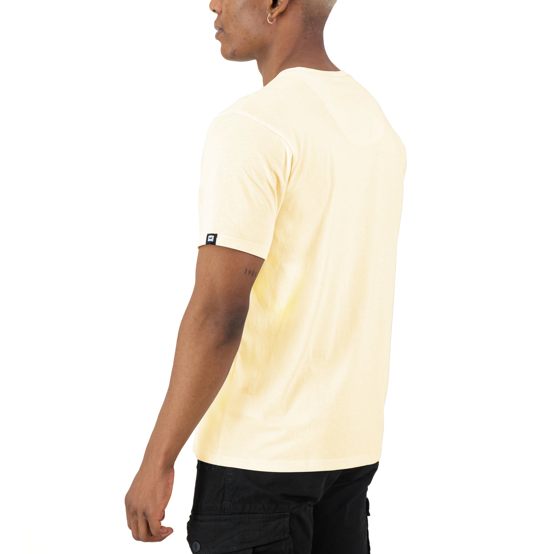 Romain Tee - Off White displayed from back view, highlighting soft-touch fabric and signature badge detail.