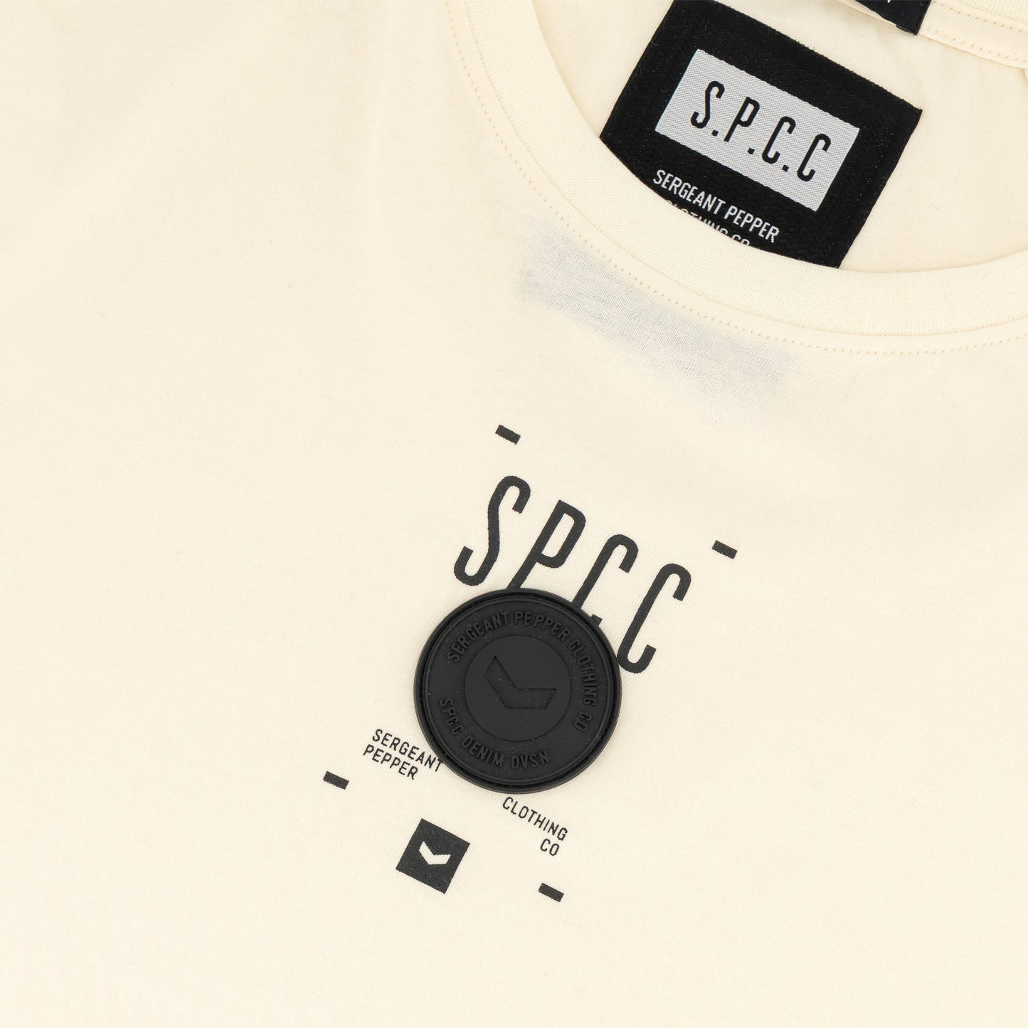 Romain Tee - Off White with SPCC print and badge detail, showcasing a streetwear-inspired design.