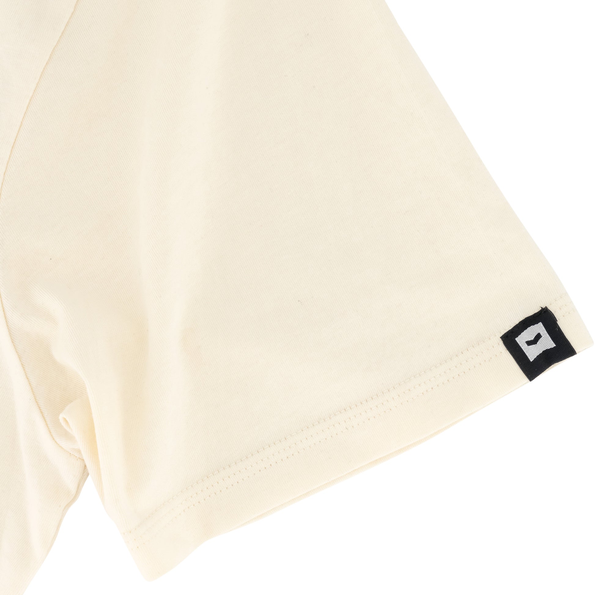 Romain Tee - Off White showcasing the SPCC woven badge on cuff and soft-touch fabric detail.